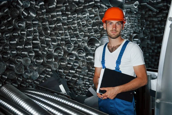 Una Pila Completa Tubi Ventilazione Uomo Uniforme Lavora Alla Produzione — Foto Stock