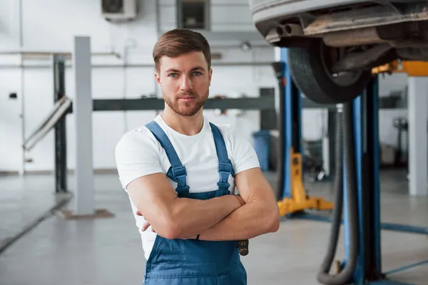 Come to us any day if you have problem with your car. Employee in the blue colored uniform works in the automobile salon.