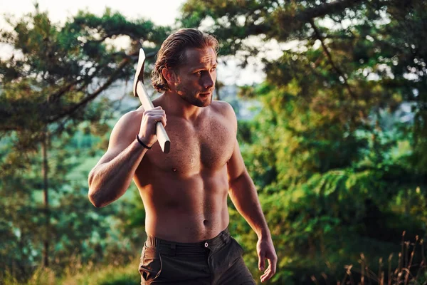 Çalışmaya hazırım. Kendine güvenen oduncu. Kaslı vücutlu yakışıklı adam gündüz vakti ormanda olur..