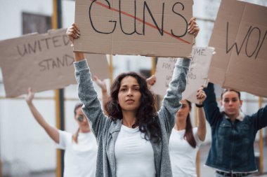 Gösteride duruyor. Bir grup feminist kadın dışarıda hakları için protesto yapıyor..
