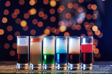 Hepsi bir resimde. Kokteyller hazır. Gece kulübündeki ahşap masada. Güzel ışıklandırma..