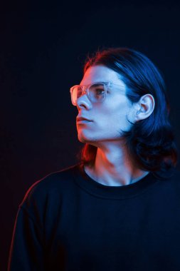 Stüdyo karanlık stüdyoda neon ışıkla çekiliyor. Ciddi bir adamın portresi..