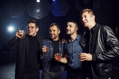 Gece hayatı kavramı. İnsanlar kulüpte eğleniyor. Ellerinde alkolle.