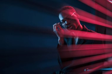 İlginç kirişler. Fütürist neon ışıkları. Stüdyodaki Afrikalı Amerikalı genç adam..