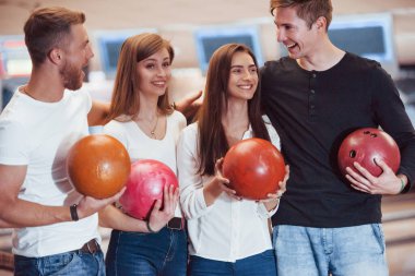 Aktif konuşma. Genç neşeli arkadaşlar hafta sonları bowling kulübünde eğleniyorlar..