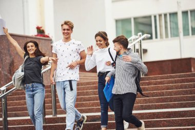 Güzel bir ruh hali ve güzel bir sohbet. Gündüz vakti üniversitenin yakınlarında günlük giysiler içinde bir grup genç öğrenci.
