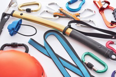 Beyaz masada yatan güvenlik için tırmanma ekipmanları. Ekstrem spor anlayışı.