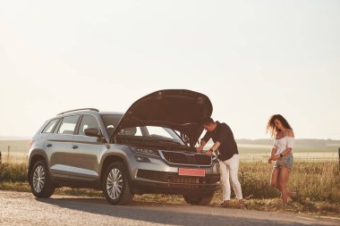 Her şey yoluna girecek. Adam kıvırcık saçlı bir kızın arabasını tamir ediyor. Mekanik yardım.