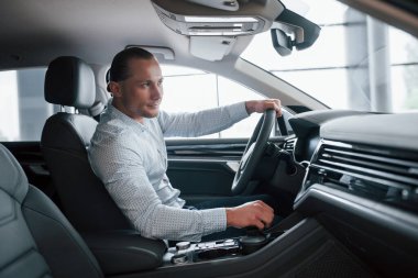 İyi adamdır. Gündüz kuaförde yeni araba deneyen bir adam. Yeni araç alınıyor.