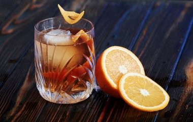 Bitmiş ve süslenmiş kokteyl. Gece kulübündeki ahşap masada. Güzel ışıklandırma..