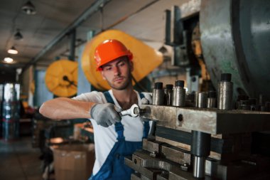 Ağır inşaat. Üniformalı adam prodüksiyonda çalışıyor. Endüstriyel modern teknoloji.