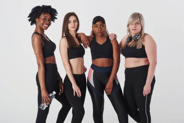 Stüdyoda beyaz arka plana karşı duran çok ırklı kadınlardan oluşan bir grup.