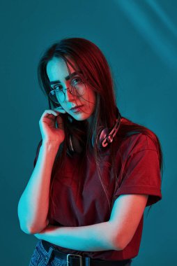 Avrupa etnik kökeni. Stüdyo içeride neon ışıkla çekiliyor. Güzel bir genç kızın portresi.