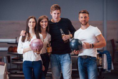 Kameraya poz veriyorum. Genç neşeli arkadaşlar hafta sonları bowling kulübünde eğleniyorlar..