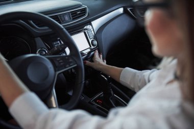 Düğmelere basıyorum. Yeni arabasında oturan güzel sarışın kız..