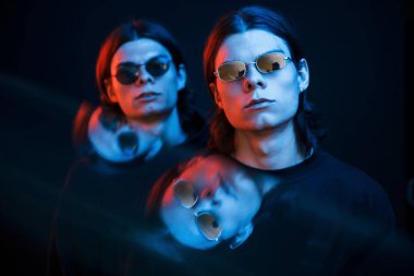 Sol taraftaki camda yansıma var. İkiz kardeşlerin portresi. Stüdyo karanlık stüdyoda neon ışıkla çekilmiştir..