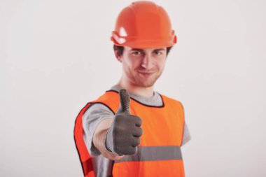 Eldivenlerin içinde. Turuncu üniformalı adam stüdyoda beyaz arka planda duruyor..