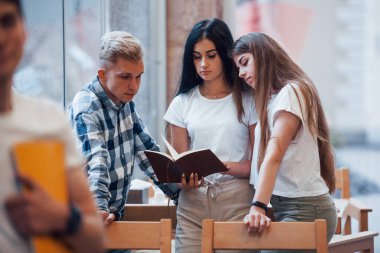 Gündelik giysiler içinde dört genç öğrenci yağmurlu bir günde buluşuyor..