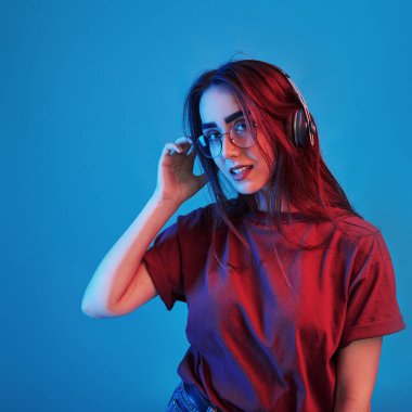 Modern teknolojiler. Stüdyo içeride neon ışıkla çekiliyor. Güzel bir genç kızın portresi.