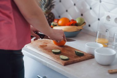 Portakal kesiyorum. Günümüz mutfağında hafta sonları evde olan bir kız..