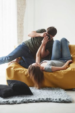Çek şu kamerayı. Fotoğrafçı, beyaz kanepede yatan genç kızın fotoğrafını çekiyor..