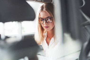 Gözlüklerdeki yansıma. Yeni arabasında oturan güzel sarışın kız..