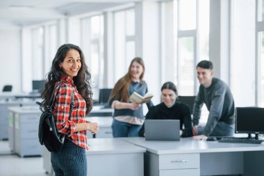 Seni burada görmek sürpriz oldu. Modern ofiste çalışan günlük kıyafetli bir grup genç..