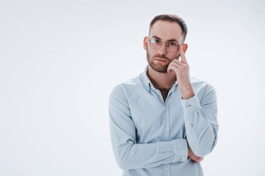 Kameraya bakıyorum. Resmi kıyafetli adam stüdyoda beyaz arka plana karşı duruyor..