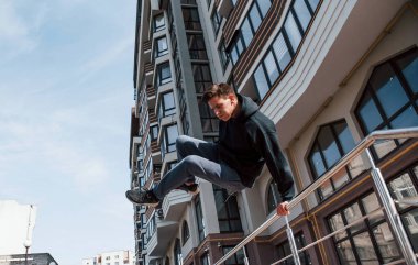 Gündüz vakti şehirde parkçılık yapan genç bir adam. Ekstrem spor anlayışı.