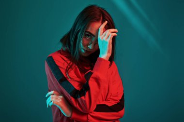 Moda modeli. Stüdyo içeride neon ışıkla çekiliyor. Güzel bir genç kızın portresi.