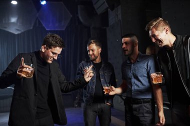 İnsanlar gece kulübünde eğleniyor. Ellerinde alkolle.