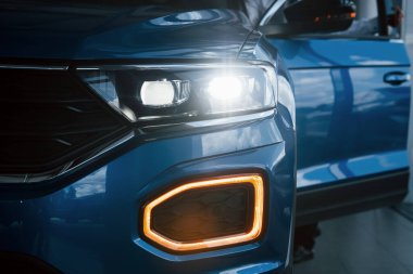 Yepyeni modern mavi arabanın ön tarafı. Galeriye park ettim. Farlardaki yansıma..