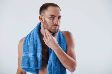 Aynaya bakıyorum. Mavi havlulu adam stüdyoda beyaz arka plana karşı duruyor..