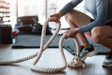 Kesilmiş fotoğraf. Sportif genç bir kadın sabah spor salonunda spor yapıyor..