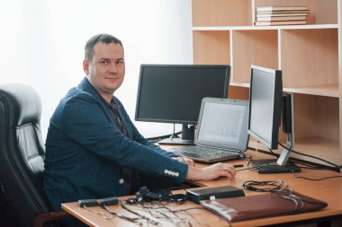 Kendi kabinesinde. Yalan makinesi müfettişi yalan makinesiyle ofiste çalışır..