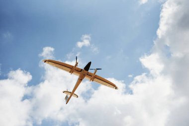 Modern küçük uzaktan kumandalı beyaz renkli uçak gökyüzünde uçuyor..