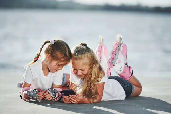 Lying Two Little Girls Roller Skates Outdoors Lake Background — Stock Photo, Image