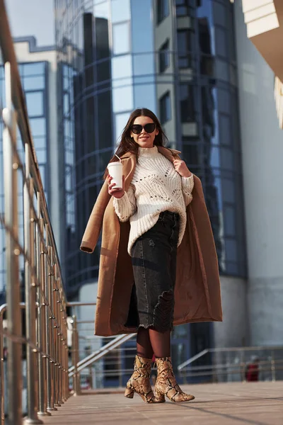 Çekici esmer. Kalın elbiseli genç bir kız hafta sonları şehirde yürür..