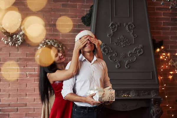 Новогодний Подарок Брюнетка Закрывает Глаза Своего Мужчины Шляпе Санты Делает — стоковое фото