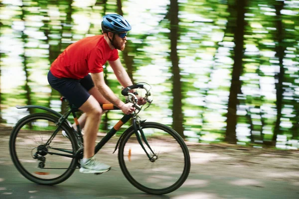感觉很好 骑自行车的人在森林里的柏油路上 — 图库照片