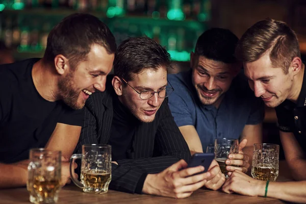 Conteúdo Engraçado Smartphone Três Amigos Descansando Bar Com Cerveja Nas — Fotografia de Stock