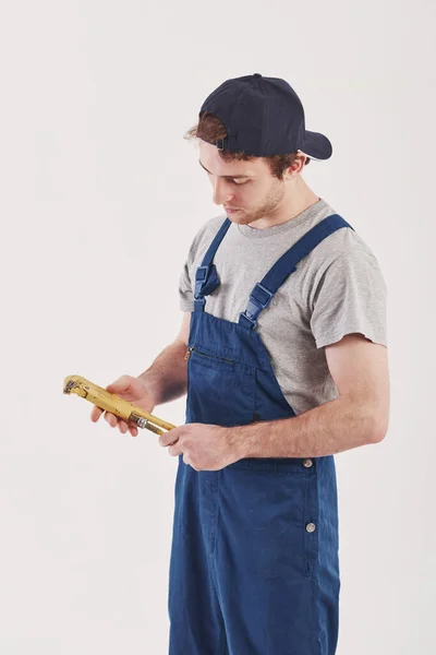 Gelber Schraubenschlüssel Den Händen Mann Blauer Uniform Steht Vor Weißem — Stockfoto