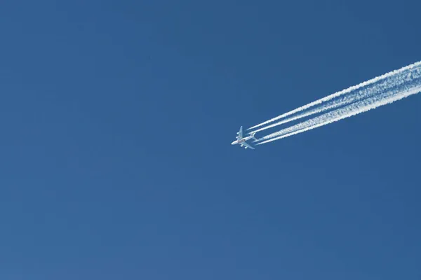 晴れた日には近代的な飛行機が青空に高く飛んでいる 速度とエネルギー — ストック写真