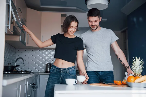 朝のコーヒー 若いですカップルで現代的なキッチンに自宅で彼らの週末の時間 — ストック写真