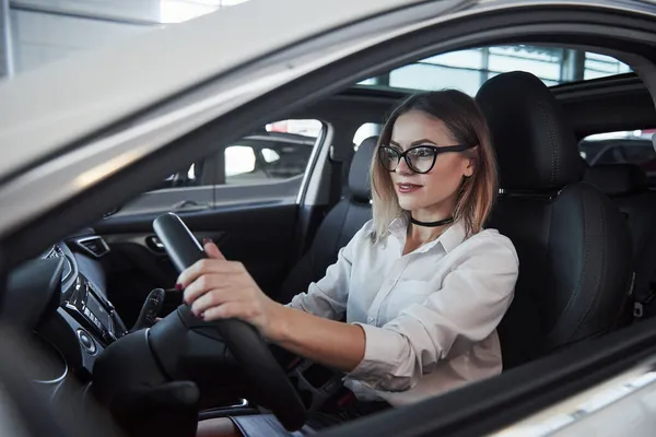 Hermosa Chica Rubia Sentada Coche Nuevo Con Interior Negro Moderno — Foto de Stock