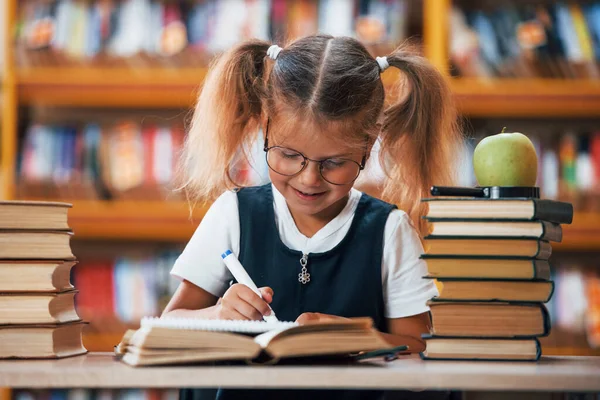 Χαριτωμένο Κοριτσάκι Τις Κοτσίδες Είναι Στη Βιβλιοθήκη Apple Στα Βιβλία — Φωτογραφία Αρχείου