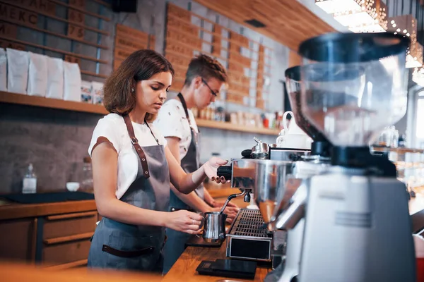 Working together. Two young cafe employees indoors. Conception of business and service.