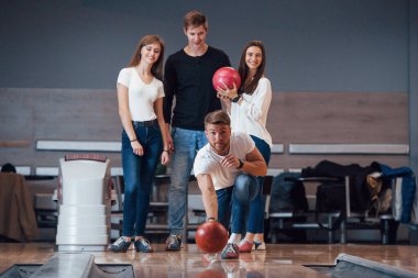 Fırlatmaya hazır. Genç neşeli arkadaşlar hafta sonları bowling kulübünde eğleniyorlar..