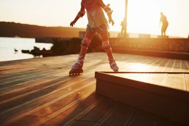 Parçacık görünümü. Çocuk paten kayıyor. İnanılmaz güneş ışığı..