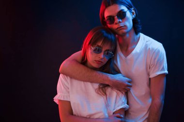 Hep birlikteyiz. Kırmızı ve mavi ışıklı, karanlık odada dikilen çift..